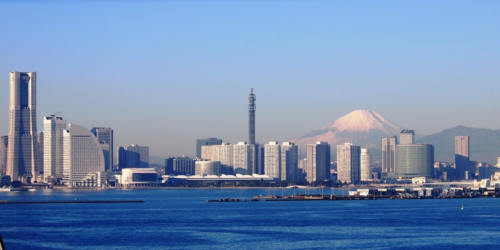 Panoramic shot of a city and mount fuji in the background on a clear blue day